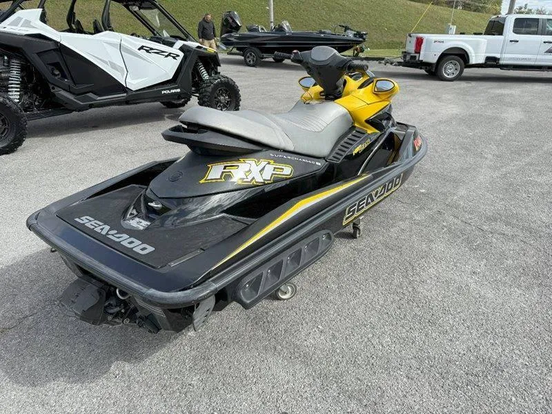 Slide: The Image of 2007 Sea-Doo RXP 215 jet ski in parking lot, black and yellow design. - 6