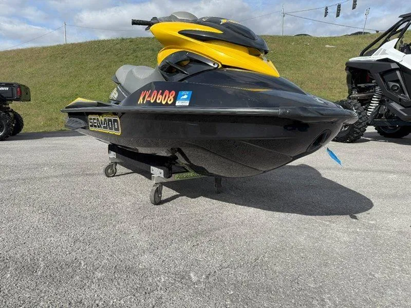 Slide: The Image of 2007 Sea-Doo RXP 215 jet ski in black and yellow on display outdoors. - 8