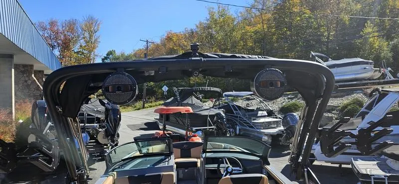 Slide: The Image of 2025 MasterCraft XT24 boat with speakers, parked outdoors in a marina setting. - 13