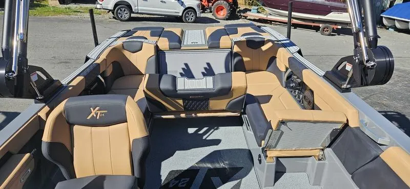 Slide: The Image of 2025 MasterCraft XT24 boat interior with tan and black seating, showcasing spacious and luxurious design. - 16
