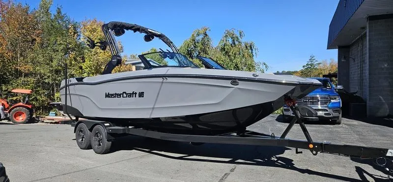 Slide: The Image of 2025 MasterCraft XT24 boat on trailer in outdoor setting. - 2