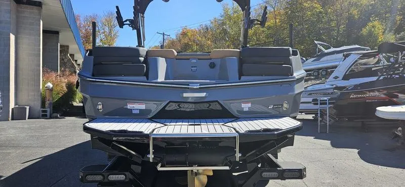 Slide: The Image of 2025 MasterCraft XT24 boat, rear view, parked outdoors on a sunny day. - 4