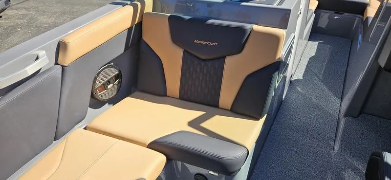 Slide: The Image of 2025 MasterCraft XT24 boat interior with tan and gray seating. - 7