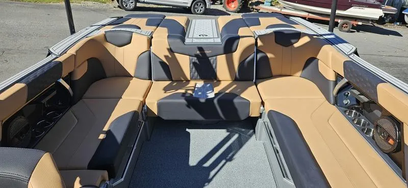 Slide: The Image of 2025 MasterCraft XT24 boat interior with tan and black seating, spacious layout. - 8