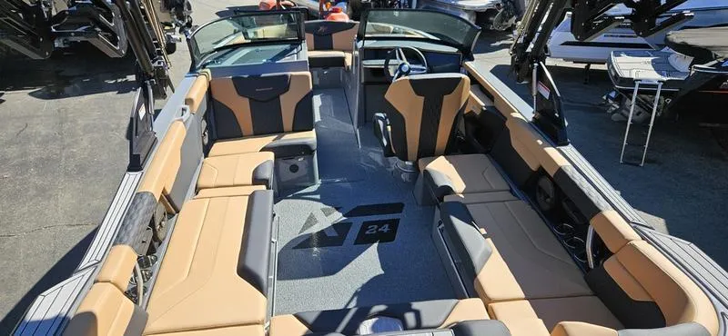 Slide: The Image of 2025 MasterCraft XT24 boat interior with tan and black seating. - 9