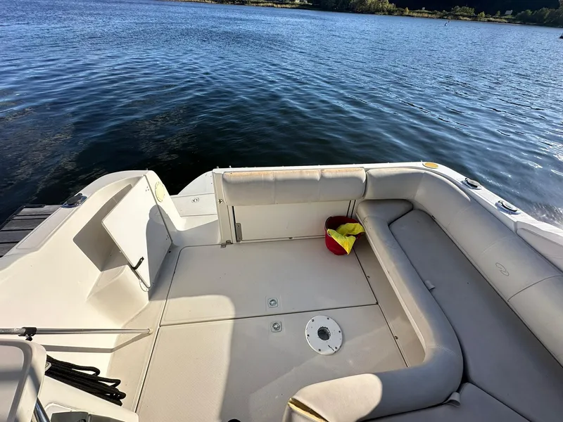 Slide: The Image of 1997 Regal 292 Commodore boat interior with seating, docked by a lake. - 10