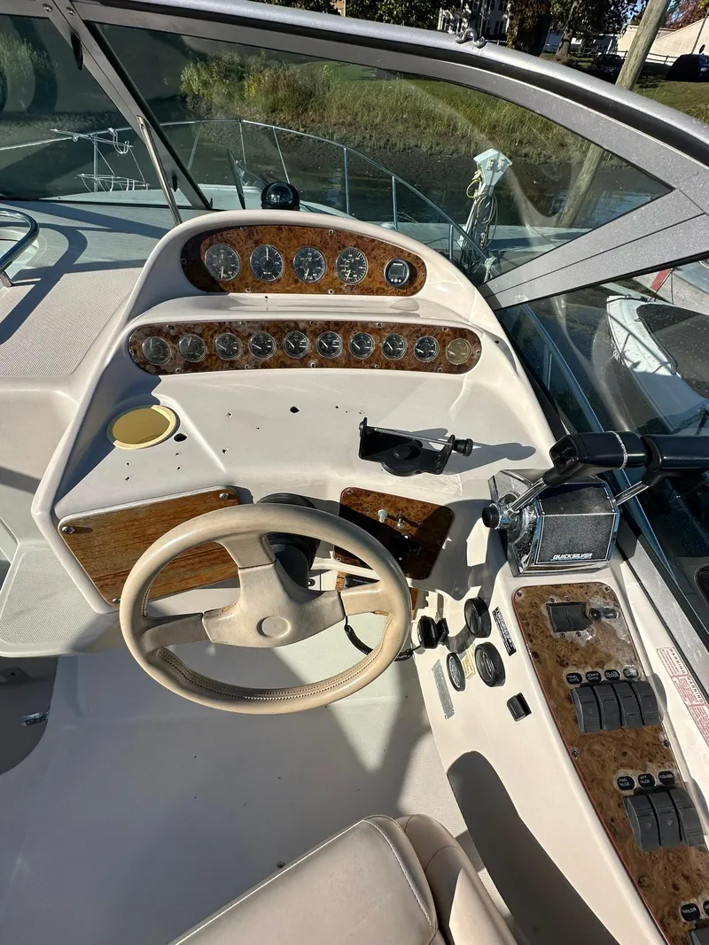 Slide: The Image of 1997 Regal 292 Commodore boat dashboard with steering wheel and control panel. - 14