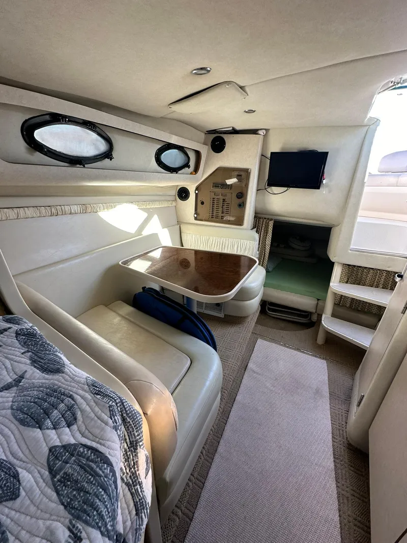 Slide: The Image of Interior of 1997 Regal 292 Commodore boat with seating, table, and TV. - 21