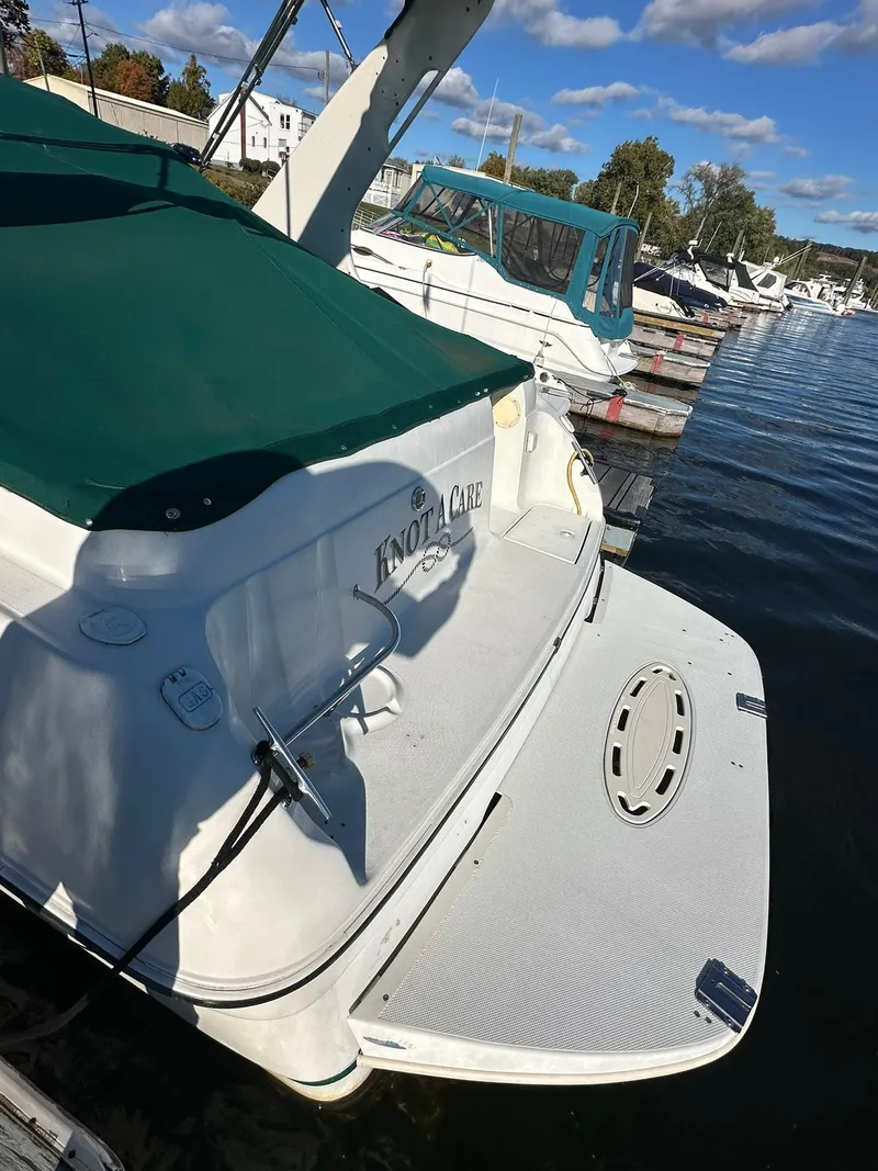 Slide: The Image of 1997 Regal 292 Commodore boat docked with green cover and swim platform. - 6
