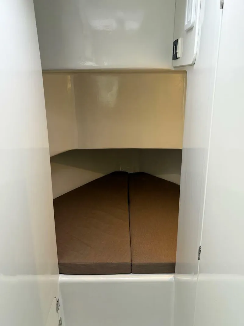 Slide: The Image of 2023 Millennium Marine NuWave Walkaround cabin interior with cushioned sleeping area. - 10