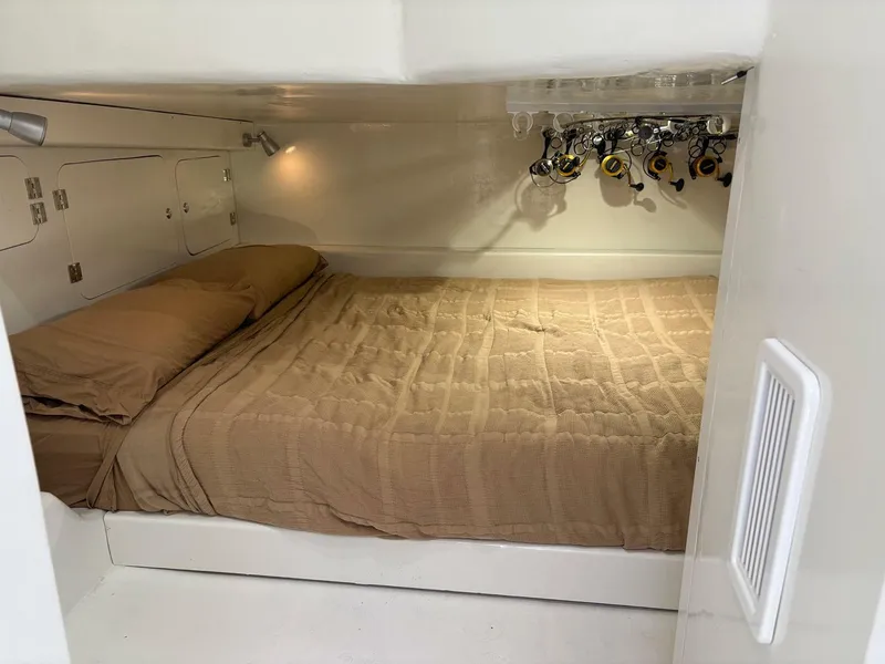 Slide: The Image of 2023 Millennium Marine NuWave Walkaround cabin with cozy bed and fishing rod storage. - 14