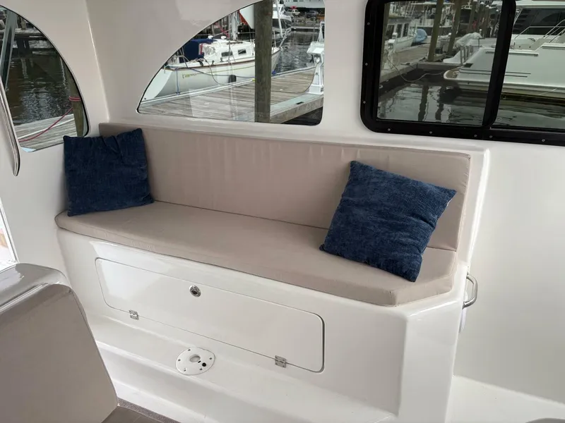 Slide: The Image of 2023 Millennium Marine NuWave Walkaround interior with cushioned seating and blue pillows. - 16