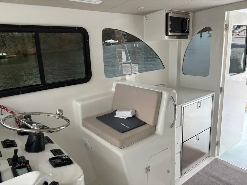 Slide: The Image of 2023 Millennium Marine NuWave Walkaround interior with helm, seating, and storage. - 17