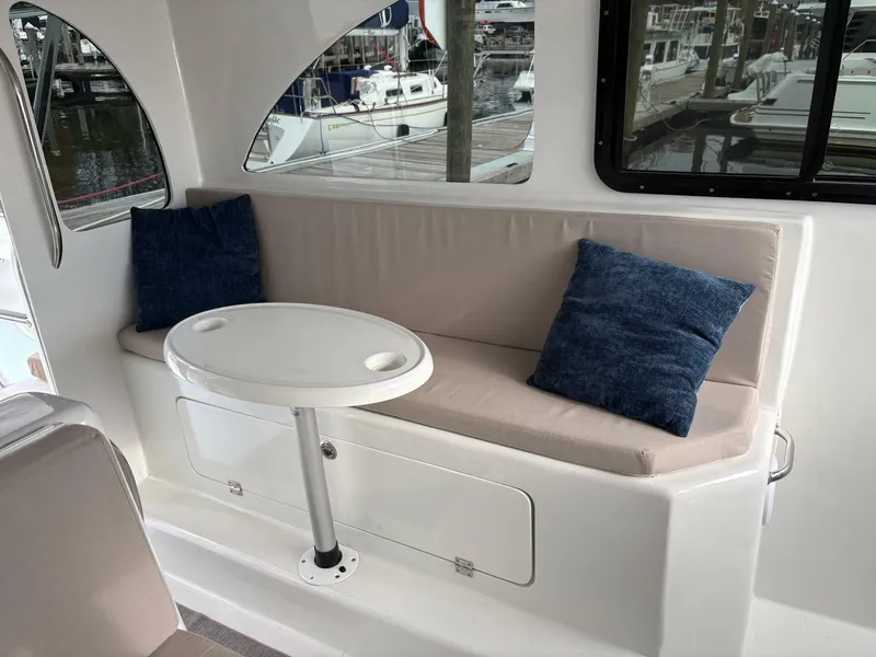 Slide: The Image of 2023 Millennium Marine NuWave Walkaround interior with cushioned seating and table. - 20