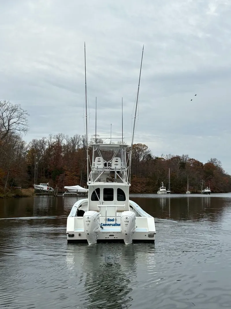 Slide: The Image of 2023 Millennium Marine NuWave Walkaround boat on calm water, surrounded by trees. - 22