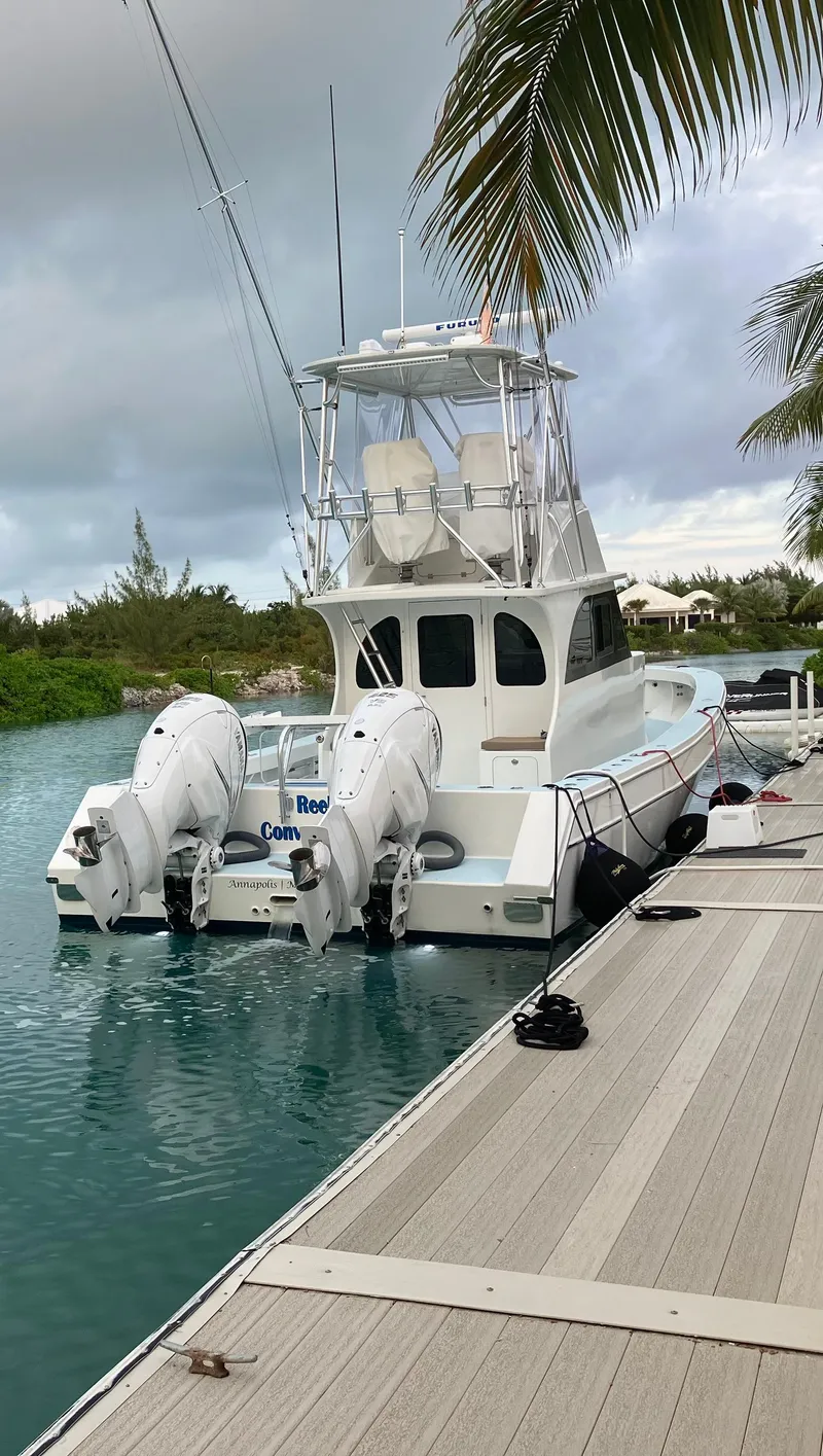 Slide: The Image of 2023 Millennium Marine NuWave Walkaround boat docked by palm trees. - 26