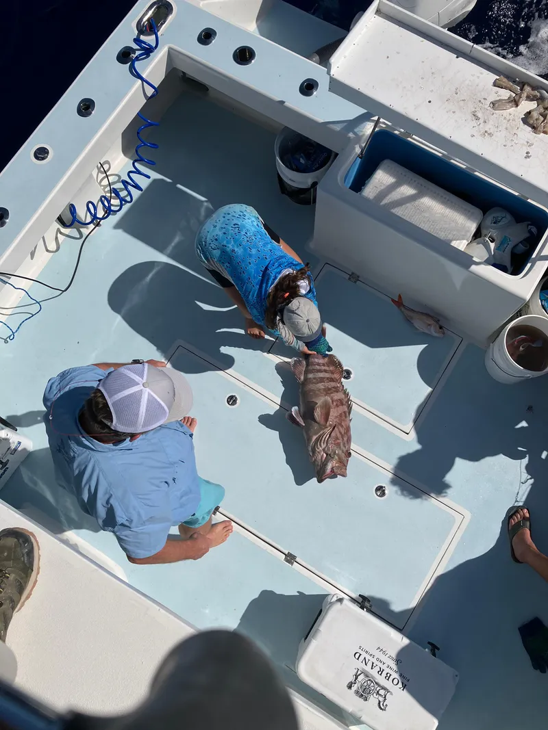 Slide: The Image of People on a 2023 Millennium Marine NuWave Walkaround boat with a large fish on deck. - 27