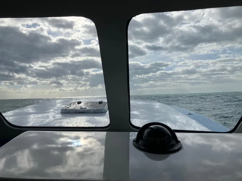 Slide: The Image of View from 2023 Millennium Marine NuWave Walkaround boat, looking out to sea under cloudy skies. - 28