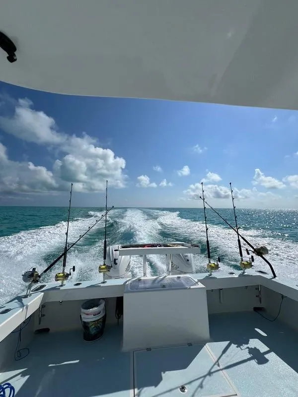 Slide: The Image of 2023 Millennium Marine NuWave Walkaround boat on open sea with fishing rods. - 31