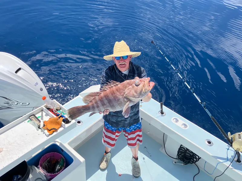 Slide: The Image of Man holding large fish on 2023 Millennium Marine NuWave Walkaround boat. - 37