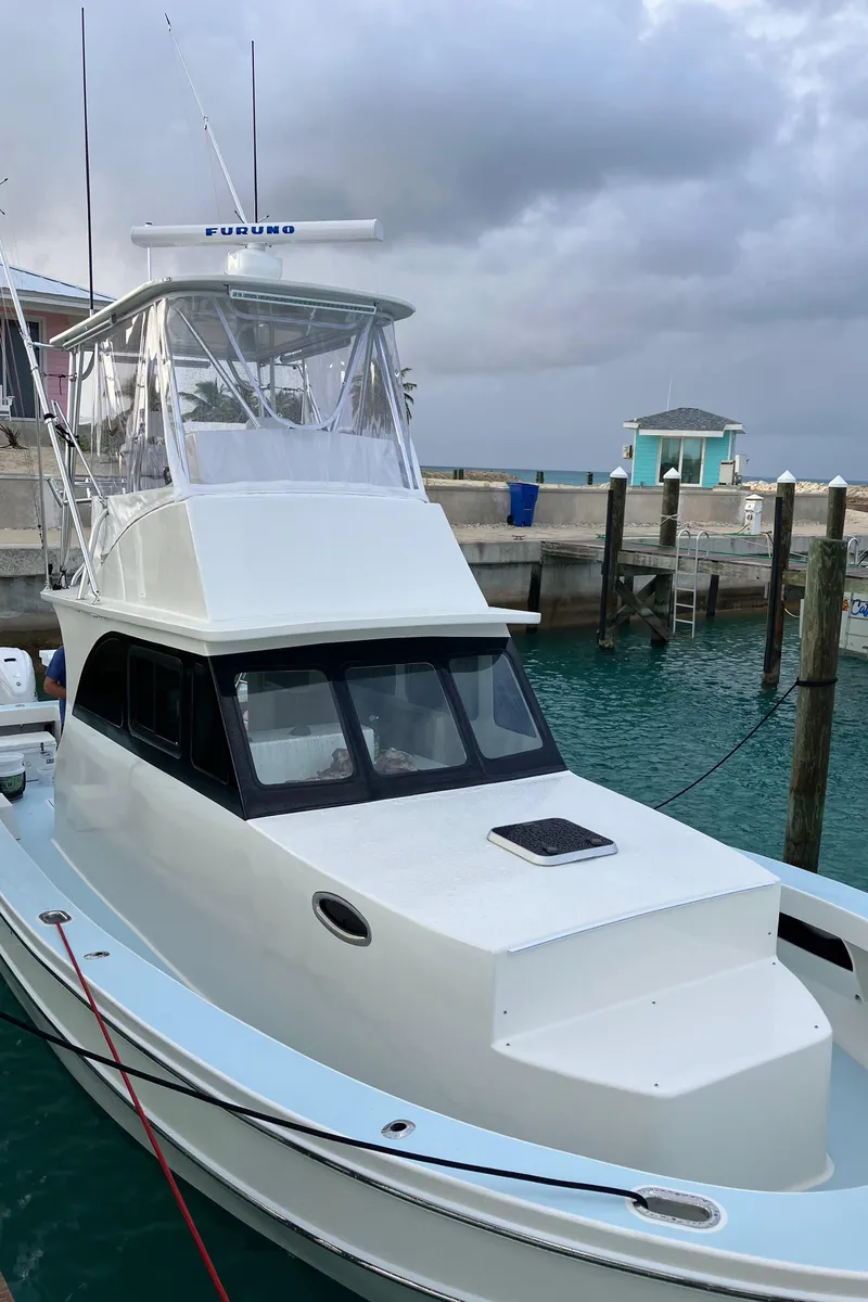 Slide: The Image of 2023 Millennium Marine NuWave Walkaround boat docked at marina under cloudy sky. - 40
