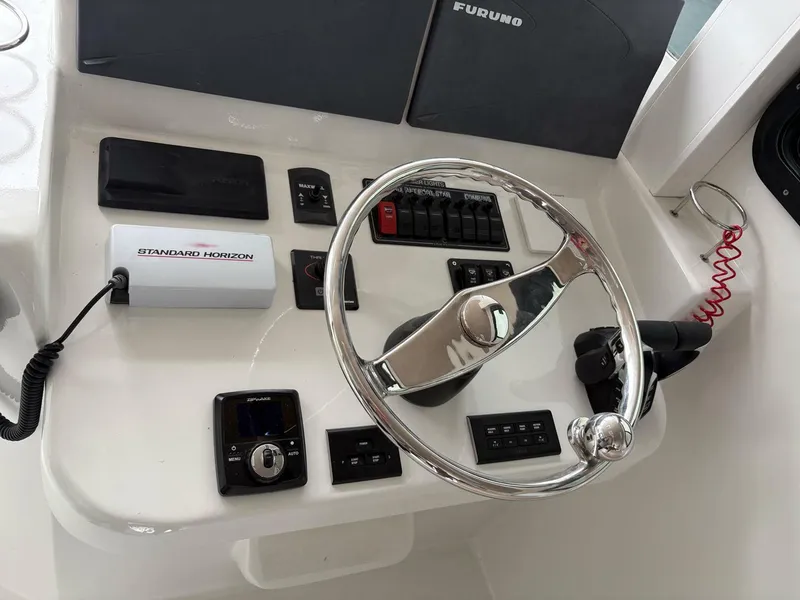 Slide: The Image of 2023 Millennium Marine NuWave Walkaround helm with steering wheel and control panel. - 8