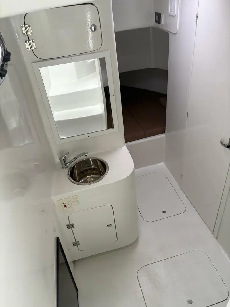 Slide: The Image of 2023 Millennium Marine NuWave Walkaround interior with sink and storage compartments. - 9