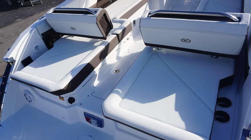 Slide: The Image of 2025 Cobalt R8 boat interior with white cushioned seating and cup holders. - 13