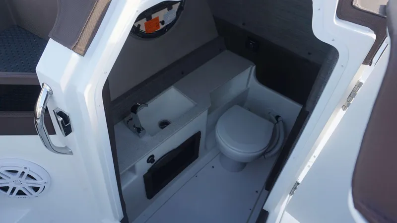 Slide: The Image of 2025 Cobalt R8 boat interior with compact bathroom, featuring a sink and toilet. - 17