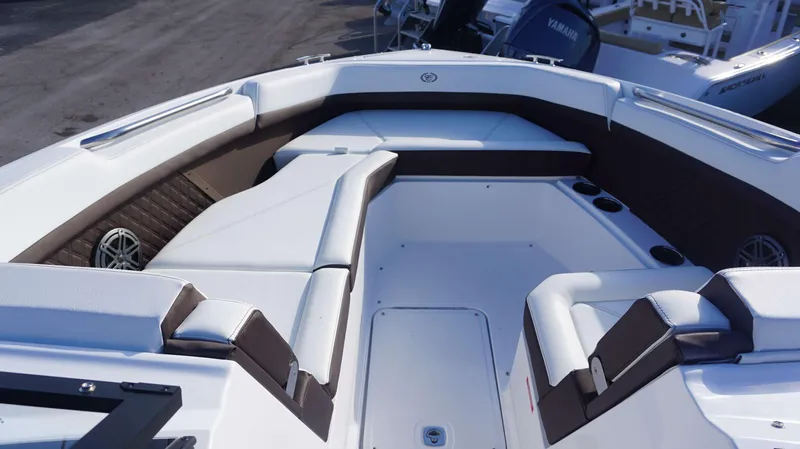 Slide: The Image of 2025 Cobalt R8 boat interior with white and brown seating, cup holders, and speakers. - 9