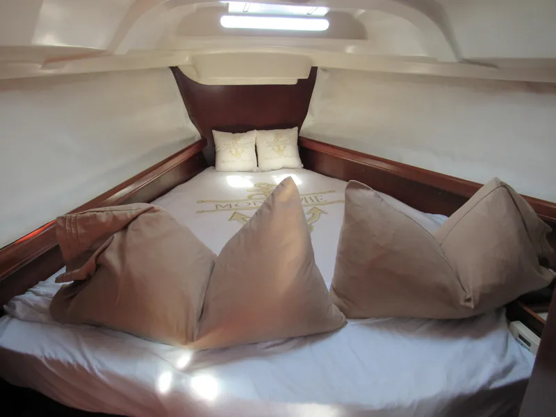 Slide: The Image of Cozy cabin interior of 1999 Beneteau 381 sailboat with plush bedding and natural light. - 12