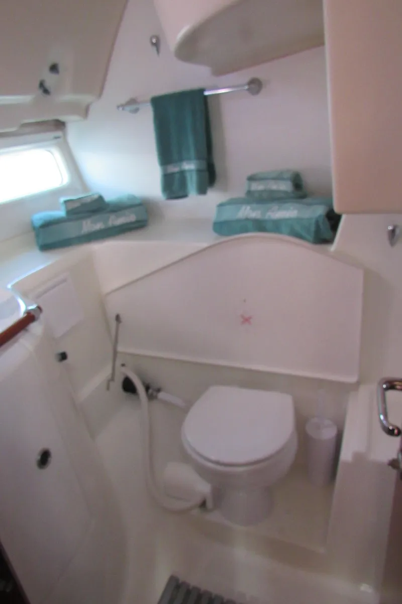 Slide: The Image of 1999 Beneteau 381 yacht bathroom with white fixtures and teal towels. - 15