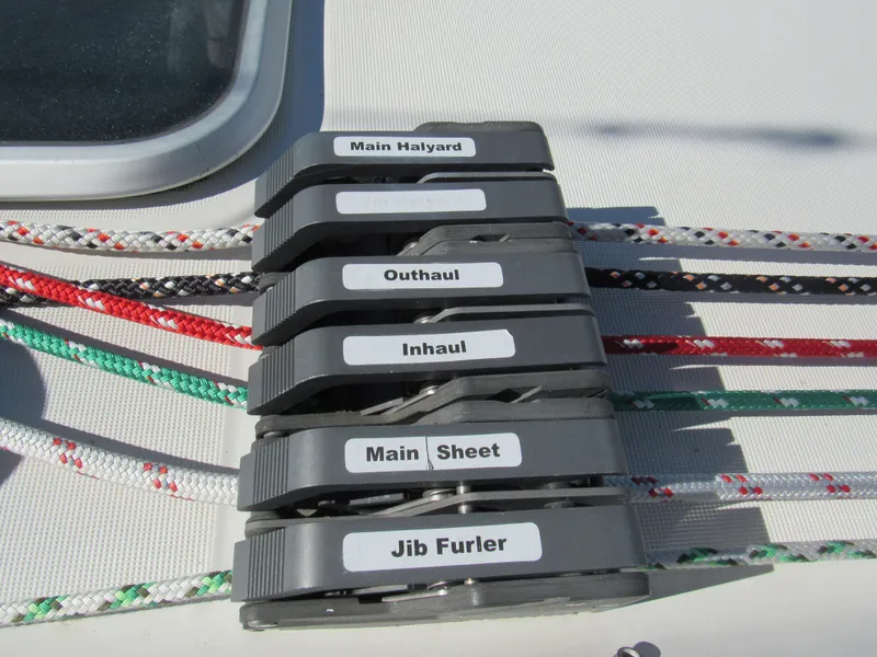 Slide: The Image of Rope clutches on a 1999 Beneteau 381 sailboat, labeled for various sailing functions. - 20
