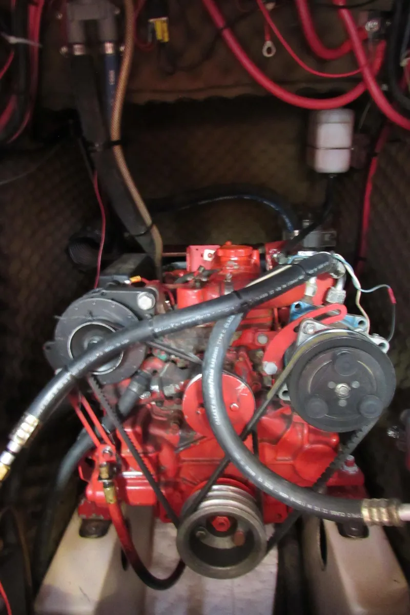 Slide: The Image of Engine compartment of a 1999 Beneteau 381 sailboat with visible red engine and hoses. - 29