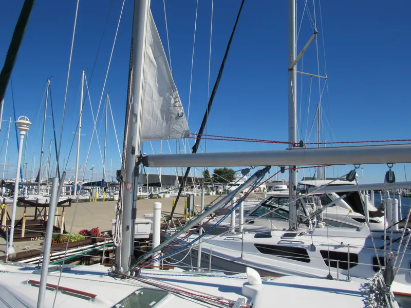 Slide: The Image of Sailboats docked at a marina, featuring a 1999 Beneteau 381 under clear blue skies. - 3