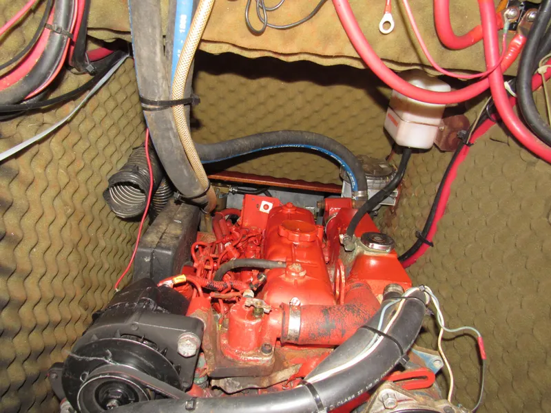 Slide: The Image of Engine compartment of a 1999 Beneteau 381 sailboat, featuring red engine and wiring. - 30