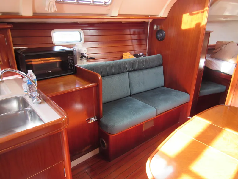 Slide: The Image of Interior of 1999 Beneteau 381 sailboat with wood finish, seating, and kitchenette. - 6