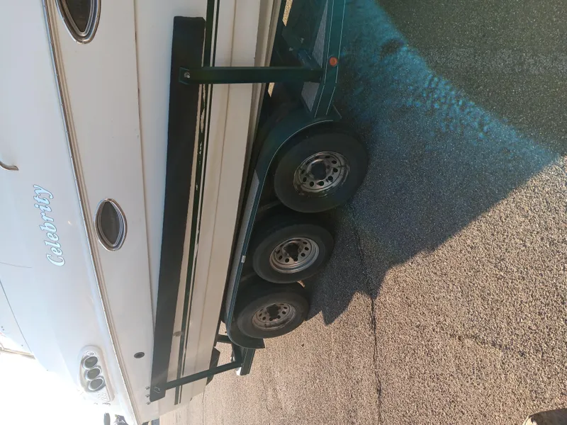 The Image of 2001 Celebrity 280 Express Cruiser on trailer, side view showing wheels and hull. - 0