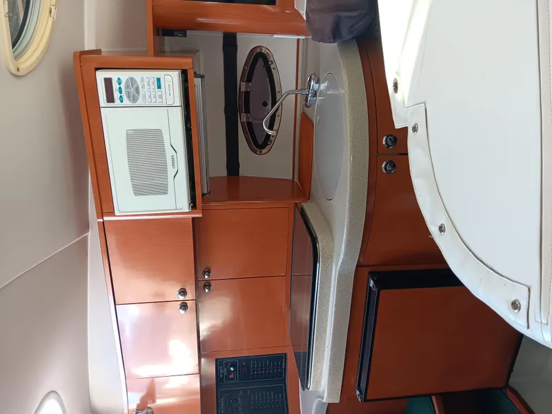 Slide: The Image of 2001 Celebrity 280 Express Cruiser interior with microwave and wooden cabinetry. - 10