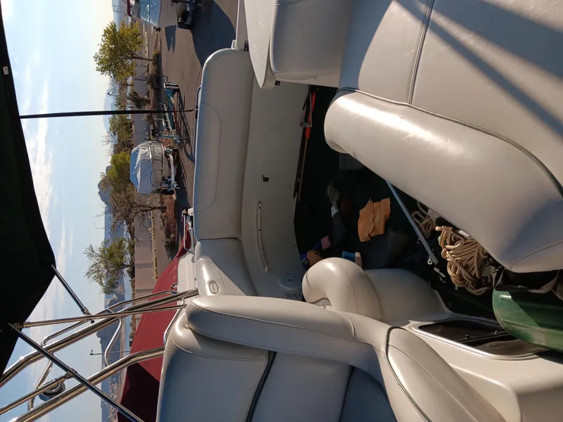 Slide: The Image of 2001 Celebrity 280 Express Cruiser interior with white seating, parked outdoors. - 16