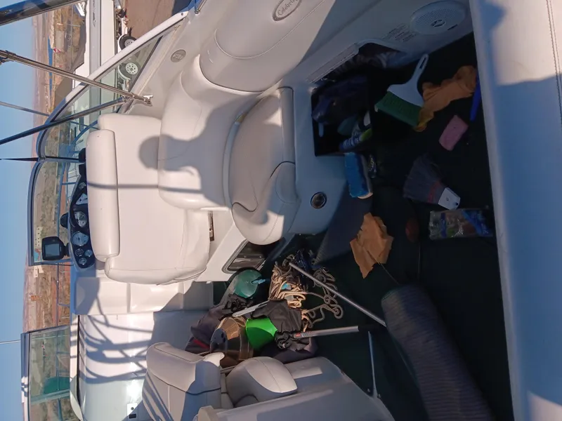 Slide: The Image of 2001 Celebrity 280 Express Cruiser interior with white seating and scattered boating gear. - 5