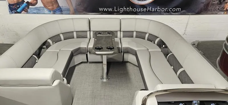 Slide: The Image of 2025 Bennington 23LSR boat interior with U-shaped seating and central table. - 2
