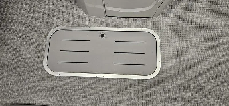 Slide: The Image of Bennington 23LSR 2025 boat floor with storage hatch, featuring a sleek gray design. - 5