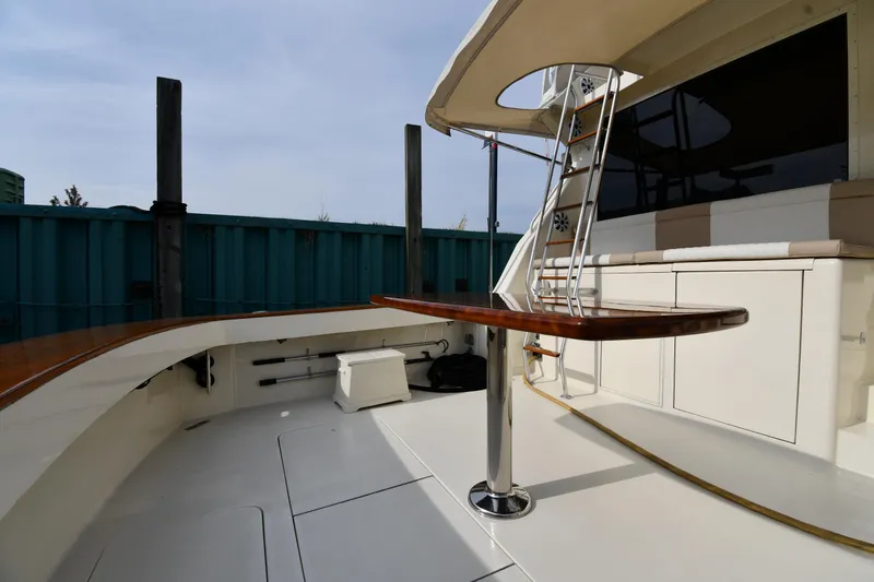 Slide: The Image of 1990 Viking 53 Convertible yacht deck with seating and ladder, showcasing luxury marine design. - 15