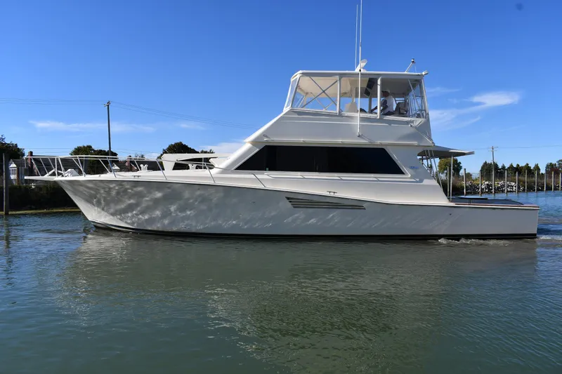 Slide: The Image of 1990 Viking 53 Convertible yacht cruising on calm water under a clear blue sky. - 2