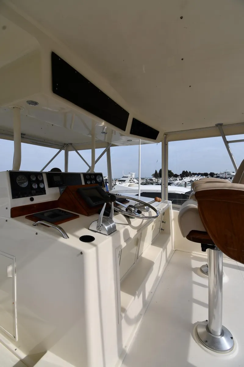 Slide: The Image of 1990 Viking 53 Convertible yacht helm with steering wheel and navigation controls. - 24