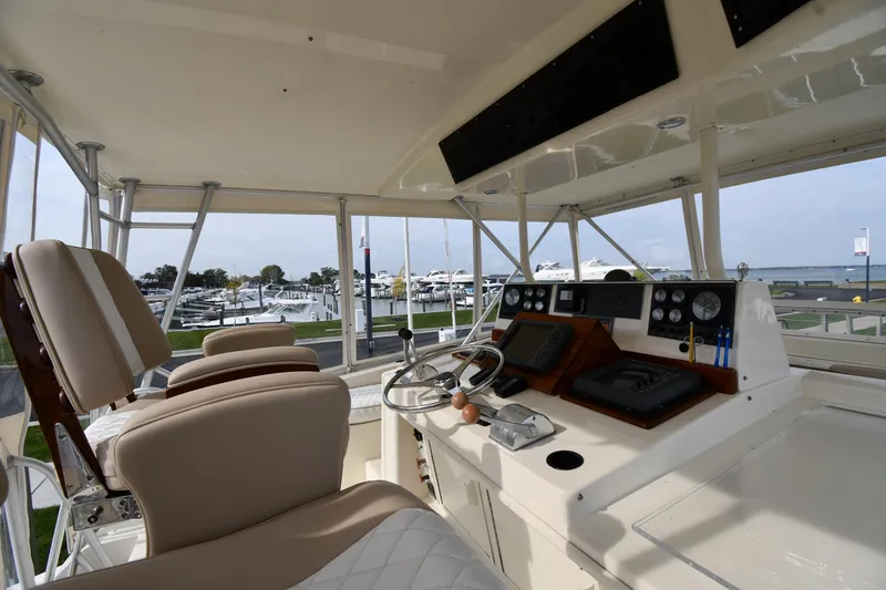 Slide: The Image of Interior view of a 1990 Viking 53 Convertible yacht's helm with modern controls and seating. - 25