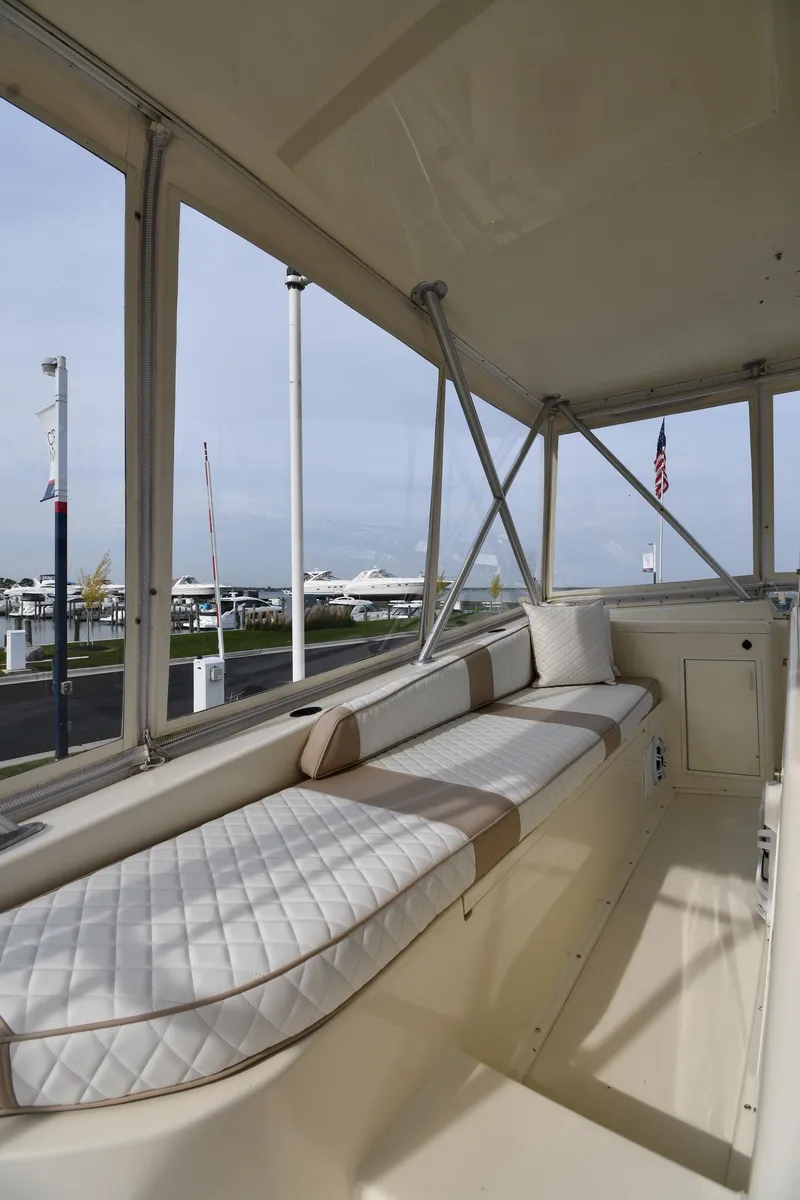 Slide: The Image of 1990 Viking 53 Convertible yacht interior with cushioned seating and marina view. - 37