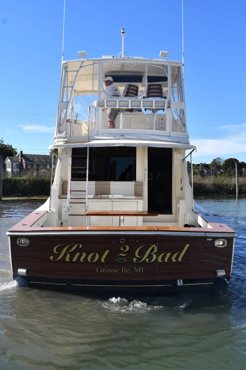 Slide: The Image of 1990 Viking 53 Convertible yacht, "Knot Bad," docked in calm waters. - 4