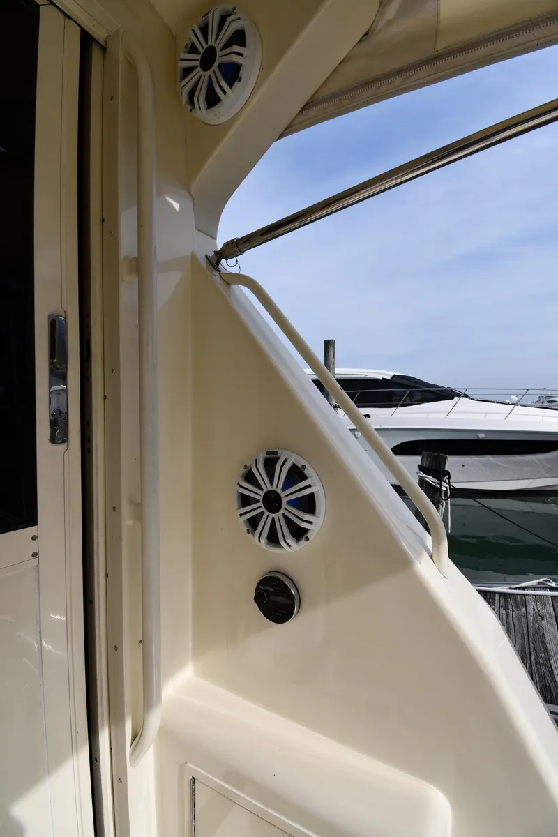 Slide: The Image of 1990 Viking 53 Convertible yacht exterior with speakers and railing, docked at marina. - 43